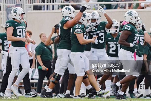 Jonathan Kim of the Michigan State Spartans celebrates with teammates after kicking a field goal in the second quarter of a game against the Richmond...