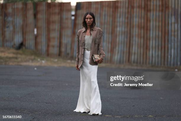 TyLinn Nguyen is seen outside Ralph Lauren show wearing brown Ralph Lauren fringe leather jacket, sequin grey top, beige Ralph Lauren leather belt...