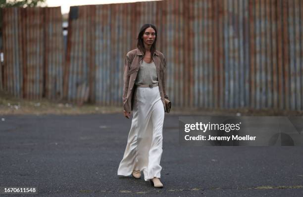 TyLinn Nguyen is seen outside Ralph Lauren show wearing brown Ralph Lauren fringe leather jacket, sequin grey top, beige Ralph Lauren leather belt...