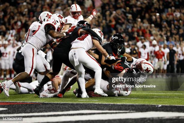 Miami Redhawks players tackle Cincinnati Bearcats running back Ryan Montgomery during the game against the Miami Redhawks and the Cincinnati Bearcats...