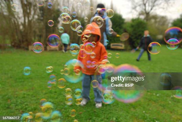 Child playing outdoors, Bulles de savon.