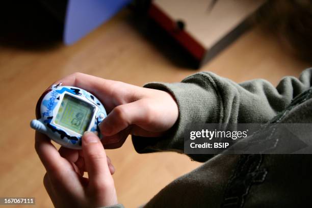 Child playing with video game, Tamagotchi.