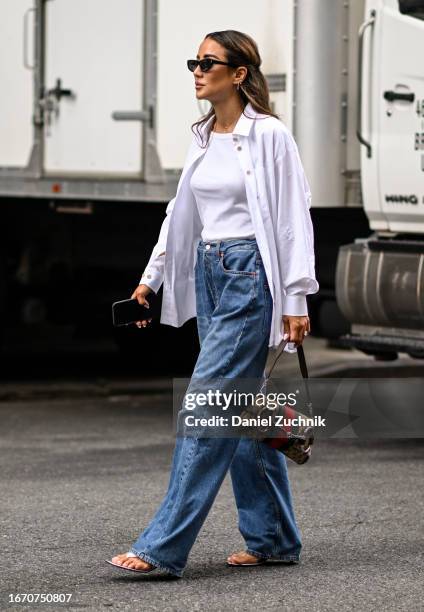 Tamara Kalinic is seen wearing a white top, white button down shirt, blue jeans and a Gucci bag with black sunglasses outside the Tibi show during...