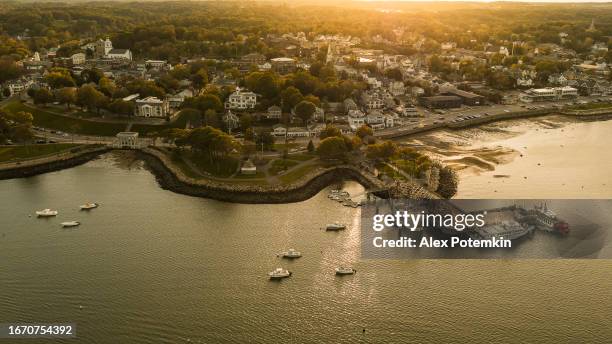 frazier state pier and plymouth rock with plymouth harbor stuffed with yachts at the backdrop at susnet. plymouth, massachusetts, usa. - hometown stockfoto's en -beelden