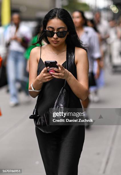 Guest is seen wearing a black dress with a Lemaire croissant bag and black sunglasses outside the Tibi show during NYFW S/S 2024 on September 09,...