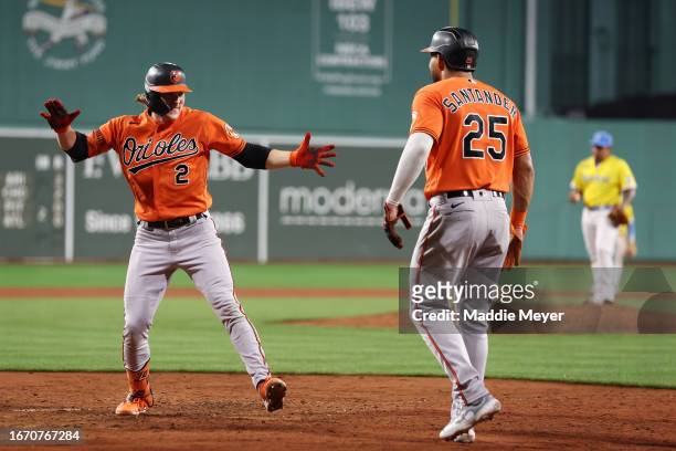 Gunnar Henderson of the Baltimore Orioles celebrates hitting a three-run home run with Anthony Santander during the sixth inning against the Boston...