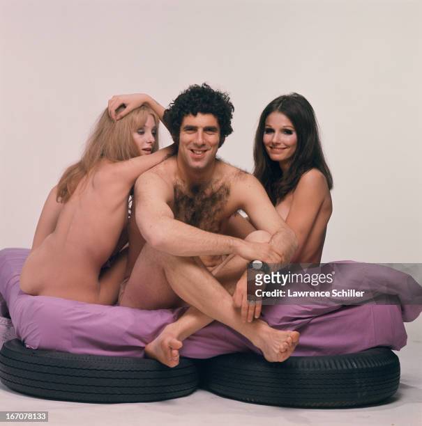 Portrait of, from left, American actors Genevieve Waïte, Elliott Gould, and Paula Prentiss, as they pose, seemingly naked, on a mattress atop car...