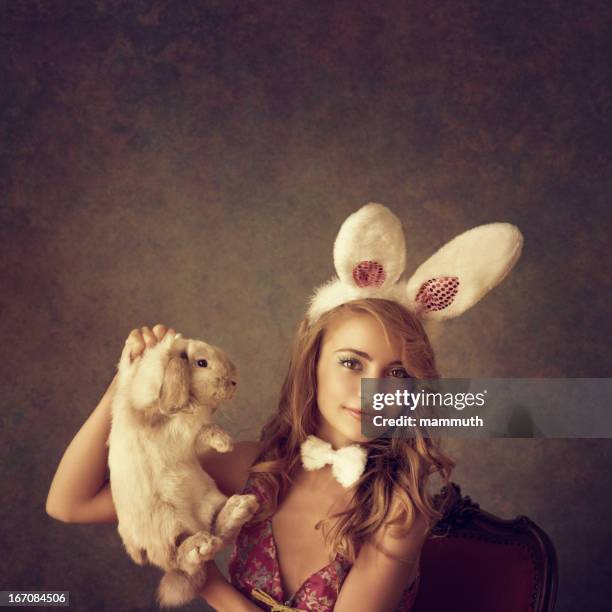 playboy-bunny holding a rabbit - adorable bunnies stock-fotos und bilder