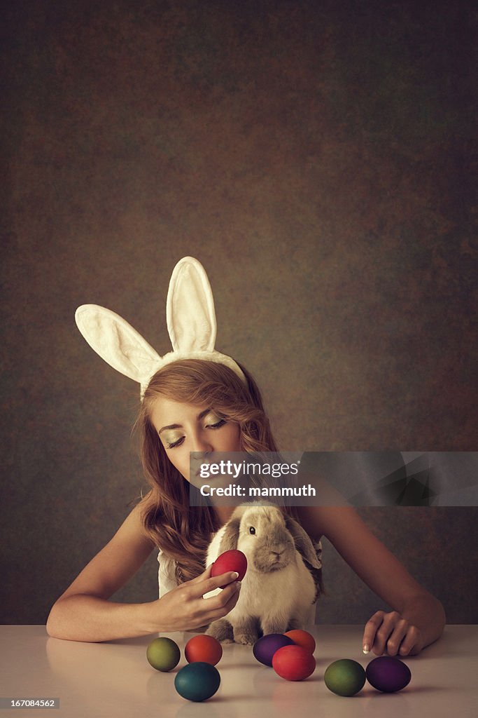 Bunny girl with baby rabbit and easter eggs