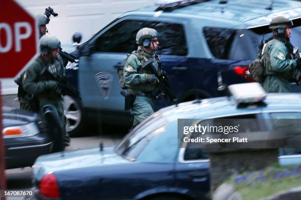 Members of a police S.W.A.T. Team run to the scene where it was believed 19-year-old bombing suspect Dzhokhar A. Tsarnaev is in hiding on April 19,...