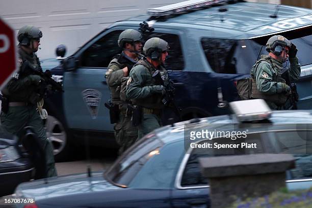 Members of a police S.W.A.T. Team run to the area where it was believed 19-year-old bombing suspect Dzhokhar A. Tsarnaev is hiding on April 19, 2013...