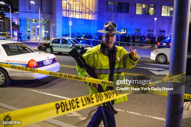 Police block road after a campus police officer at Massachusetts Institute of Technology was shot near Building 32 during hunt for two suspects in...