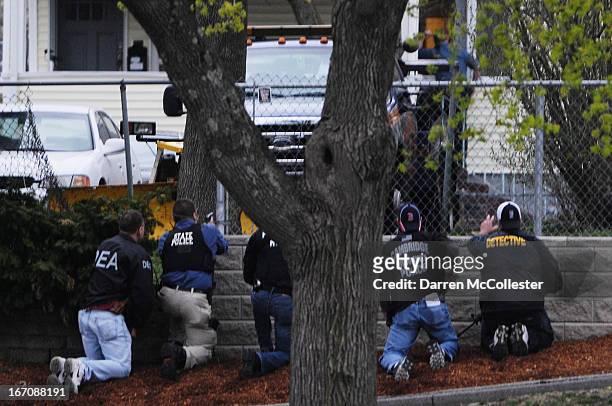 Law enforcement approach an area reportedly where a suspect is hiding on Franklin St., on April 19, 2013 in Watertown, Massachusetts. After a car...