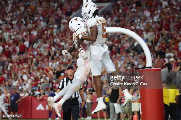 Adonai Mitchell of the Texas Longhorns celebrates his touchdown catch with Xavier Worthy during the fourth quarter against the Alabama Crimson Tide...