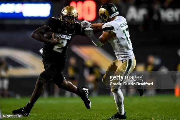 Quarterback Shedeur Sanders of the Colorado Buffaloes scrambles against defensive back Jack Howell of the Colorado State Rams in the fourth quarter...