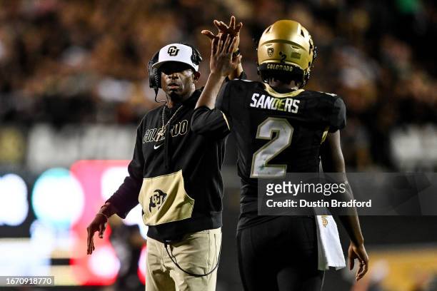 Head coach Deion Sanders of the Colorado Buffaloes celebrates with quarterback Shedeur Sanders after a fourth quarter touchdown against the Colorado...