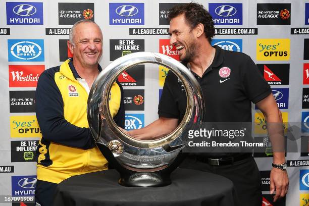 Mariners coach, Graham Arnold and Wanderers coach, Tony Popovic shake hands in front of the Hyundai A-League Champions Trophy during the A-League...