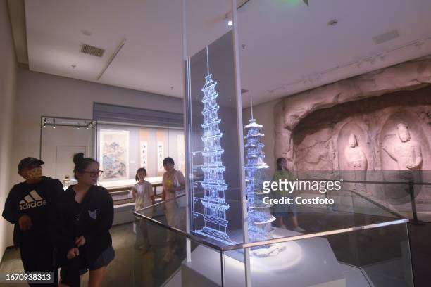 Visitors look at a digital ancient pagoda restored using 3D digital technology at Hangzhou West Lake Museum in Hangzhou, Zhejiang province, China,...