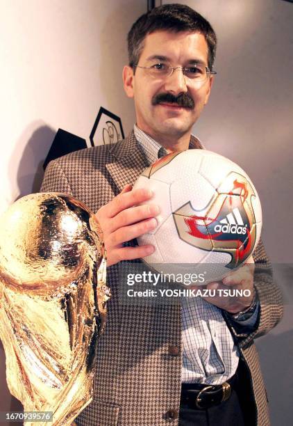 Adidas CEO Herbert Hainer unveils the official match ball next to the tournament trophy for the World Cup 2002 in Pusan, 30 November 2001, one day...