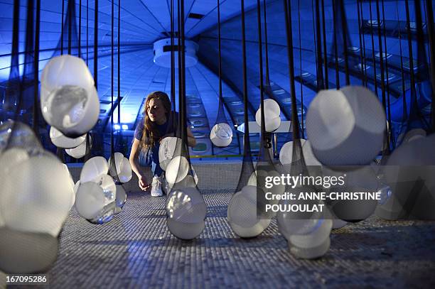 Person looks at the art creation "PIP Show" by French artist Camille Lorin made with fishnet stockings containing breast implants from the Poly...