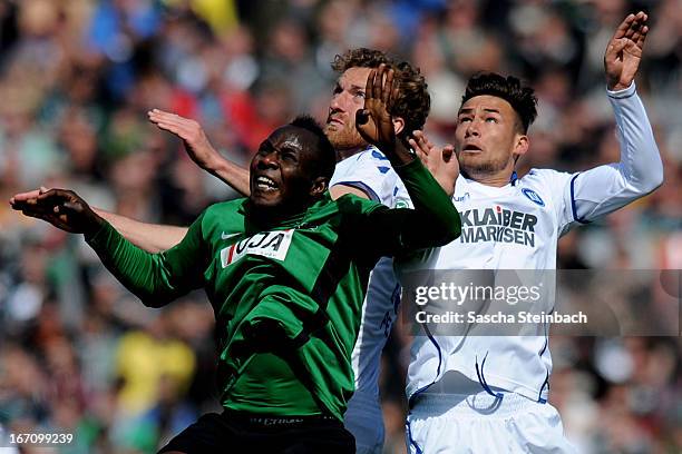 Addy Waku Menga of Muenster, Dominic Peitz and Danny Blum of Karlsruhe battle for and header during the 3. Liga match between Preussen Muenster and...