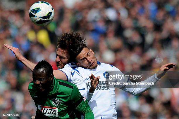 Addy Waku Menga of Muenster, Dominic Peitz and Danny Blum of Karlsruhe battle for and header during the 3. Liga match between Preussen Muenster and...