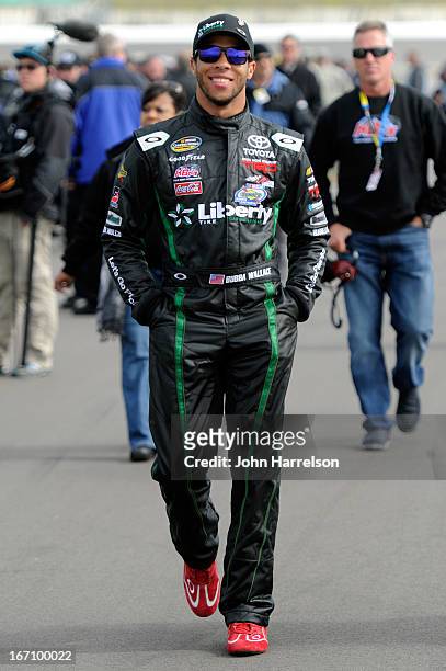 Darrell Wallace Jr., driver of the LibertyTireRecycling/Ground SmartRubber Toyota, walks on the grid during qualifying for the NASCAR Camping World...