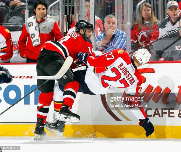 Nick Bjugstad of the Florida Panthers is checked off his feet by Adam Henrique of the New Jersey Devils during the game at the Prudential Center on...