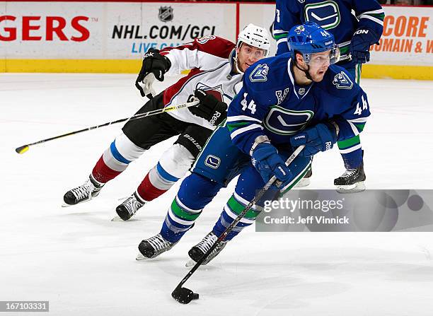 Aaron Palushaj of the Colorado Avalanche skates after Andrew Gordon of the Vancouver Canucks as he skates up ice with the puck during an NHL game at...