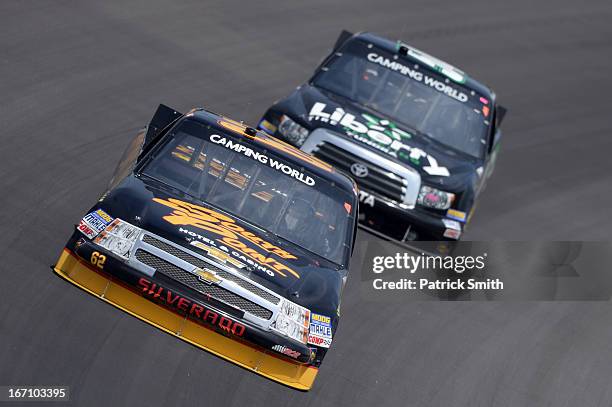 Brendan Gaughan, driver of the South Point Chevrolet, races Darrell Wallace Jr., driver of the LibertyTireRecycling/Ground SmartRubber Toyota, during...