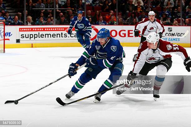 Cody McLeod of the Colorado Avalanche checks Christopher Tanev of the Vancouver Canucks during an NHL game at Rogers Arena March 28, 2013 in...