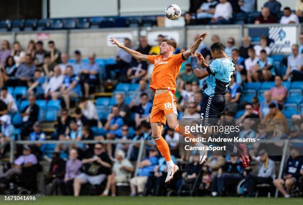 Blackpool's Jake Beesley competing in the air with Wycombe Wanderers' Chris Forino-Joseph during the Sky Bet League One match between Wycombe...