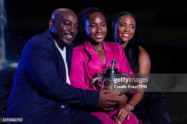 Coco Gauff of the United States poses with her parents Corey and Candi Gauff with the winner's trophy outside Arthur Ashe Stadium after beating Aryna...