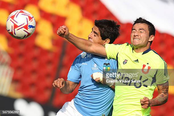 Clarence Acua of Universidad de Chile, struggles for the ball with Julio Barroso of O'Higgins during a match between Universidad de Chile and...