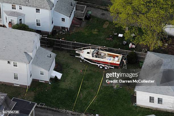 Investigators work around the boat where Dzhokhar A. Tsarnaev was found hiding after a massive manhunt, in the backyard of a Franklin Street home, in...