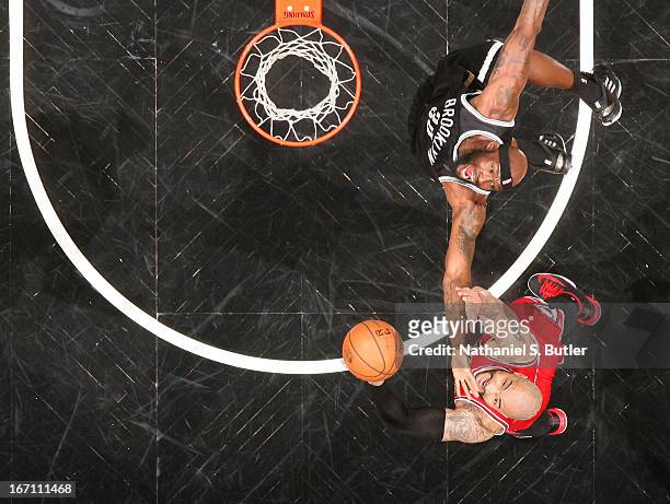 Carlos Boozer of the Chicago Bulls reaches for a rebound against Reggie Evans of the Brooklyn Nets in Game One of the Eastern Conference...