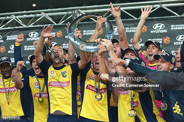 Mariners captain John Hutchinson, Patrick Zwaanswijk of the Mariners and team mates celebrate with the trophy after winning the A-League 2013 Grand...