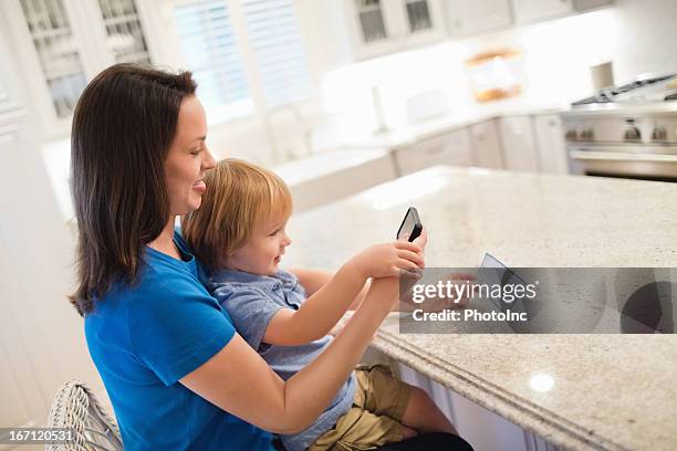 mother and son depositing check through smart phone - cheque deposit stock pictures, royalty-free photos & images