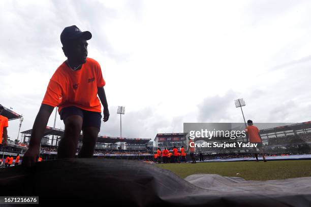 Ground staff cover the field during a rain delay in the Asia Cup Final match between India and Sri Lanka at R. Premadasa Stadium on September 17,...