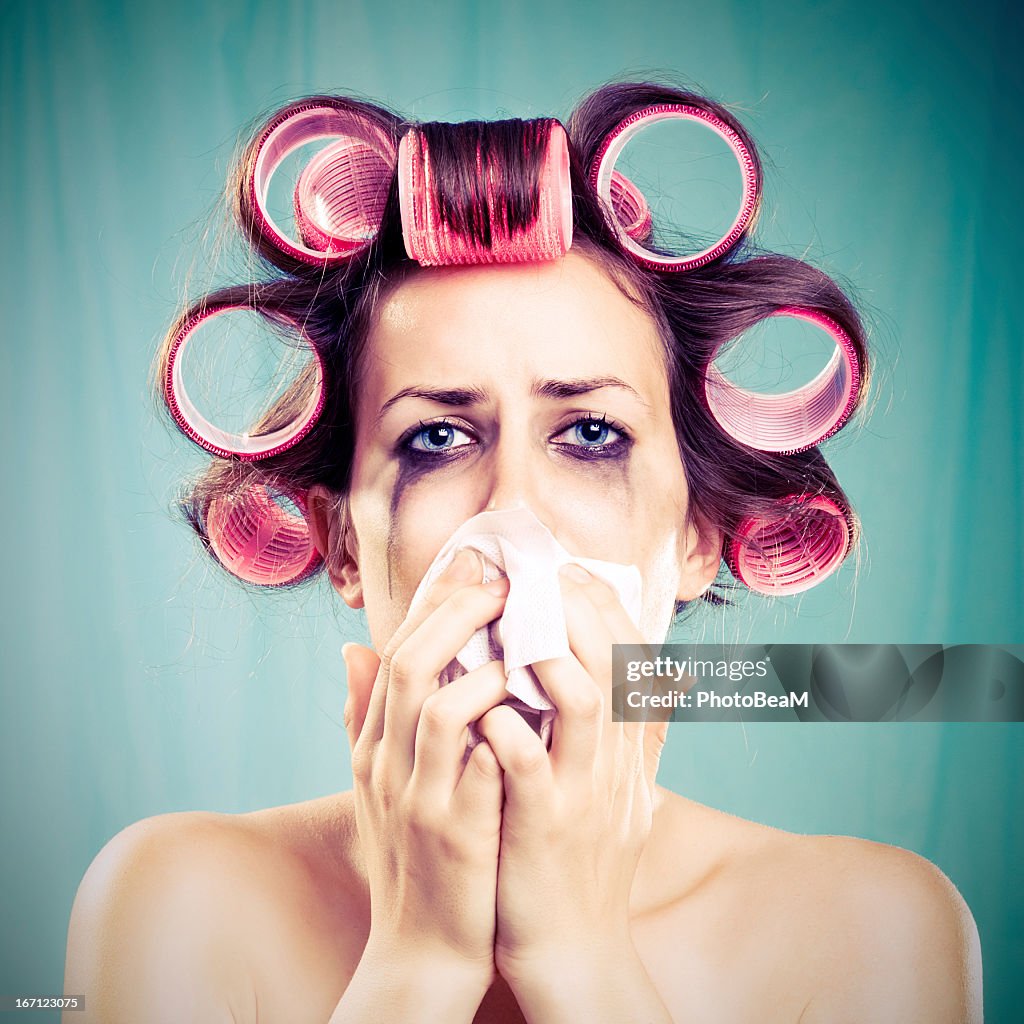 Woman crying with pink hair curlers