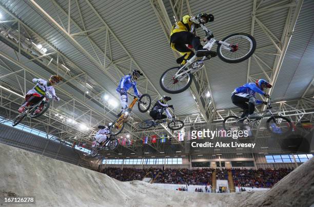 Cyclists take a jump during the Men's Elite 1/8 Finals in the UCI BMX Supercross World Cup at the National Cycling Centre on April 20, 2013 in...