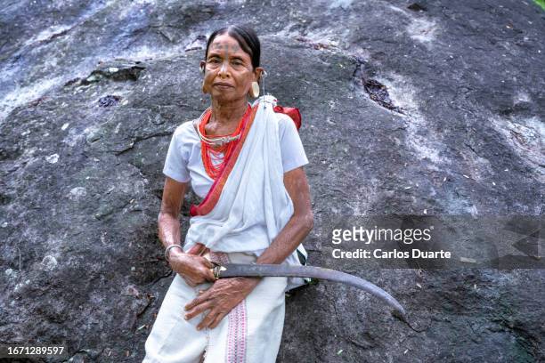 woman from the lanjia saura tribe in the jungle with a bowie knife of the odisha region. this tribe is the only tribe of aryan race in india. - bowie knife stock-fotos und bilder