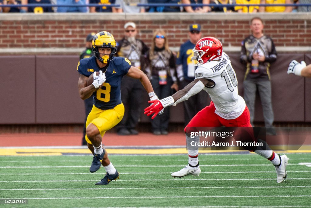 Tyler Rook Michigan Tyler Morris of the Michigan Wolverines runs with the ball past Fred ...