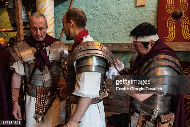 Actors dressed as ancient Roman soldiers dress up before to march in a commemorative parade during festivities marking the 2,766th anniversary of the...