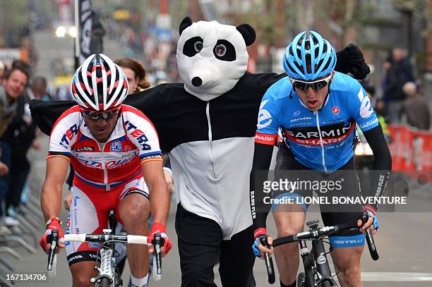 Man dressed as a panda runs near Spain's Joaquim Rodriguez Olivier of the Katusha team and Ireland's Daniel Martin of the Garmin-Sharp team who...