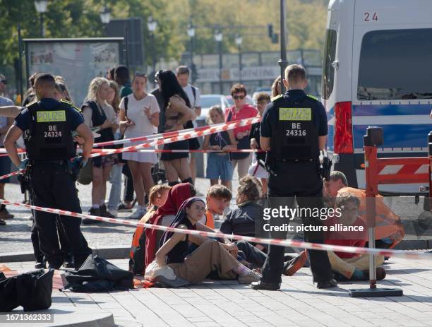 September 2023, Berln, Berlin: Police officers stand at the Brandenburg Gate around a group of arrested members of the climate protection group Last...