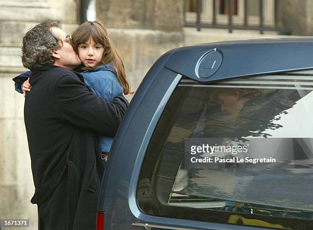 Manuel Gelin kisses his dauther as they attend the funeral service for his father, French actor Daniel Gelin, December 4, 2002 in Paris. Gelin, known...