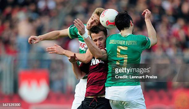 Tomas Pekhart of Nuernberg is challenged by Mergim Mavraj and Bernd Nehrig of Fuerth during the Bundesliga match between 1. FC Nuernberg and SpVgg...