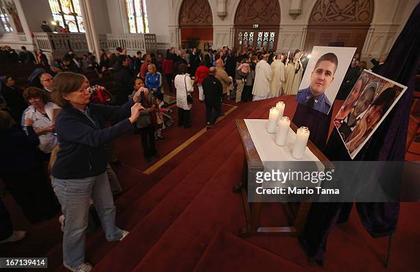 Photos of the deceased are displayed following Mass at the Cathedral of the Holy Cross on the first Sunday after the Boston Marathon bombings on...