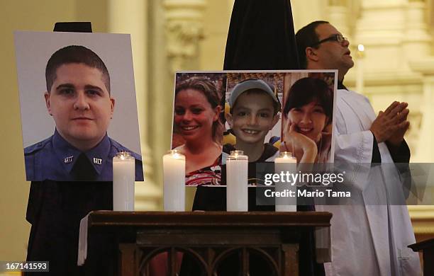 Photos of the deceased are displayed during Mass at the Cathedral of the Holy Cross on the first Sunday after the Boston Marathon bombings on April...